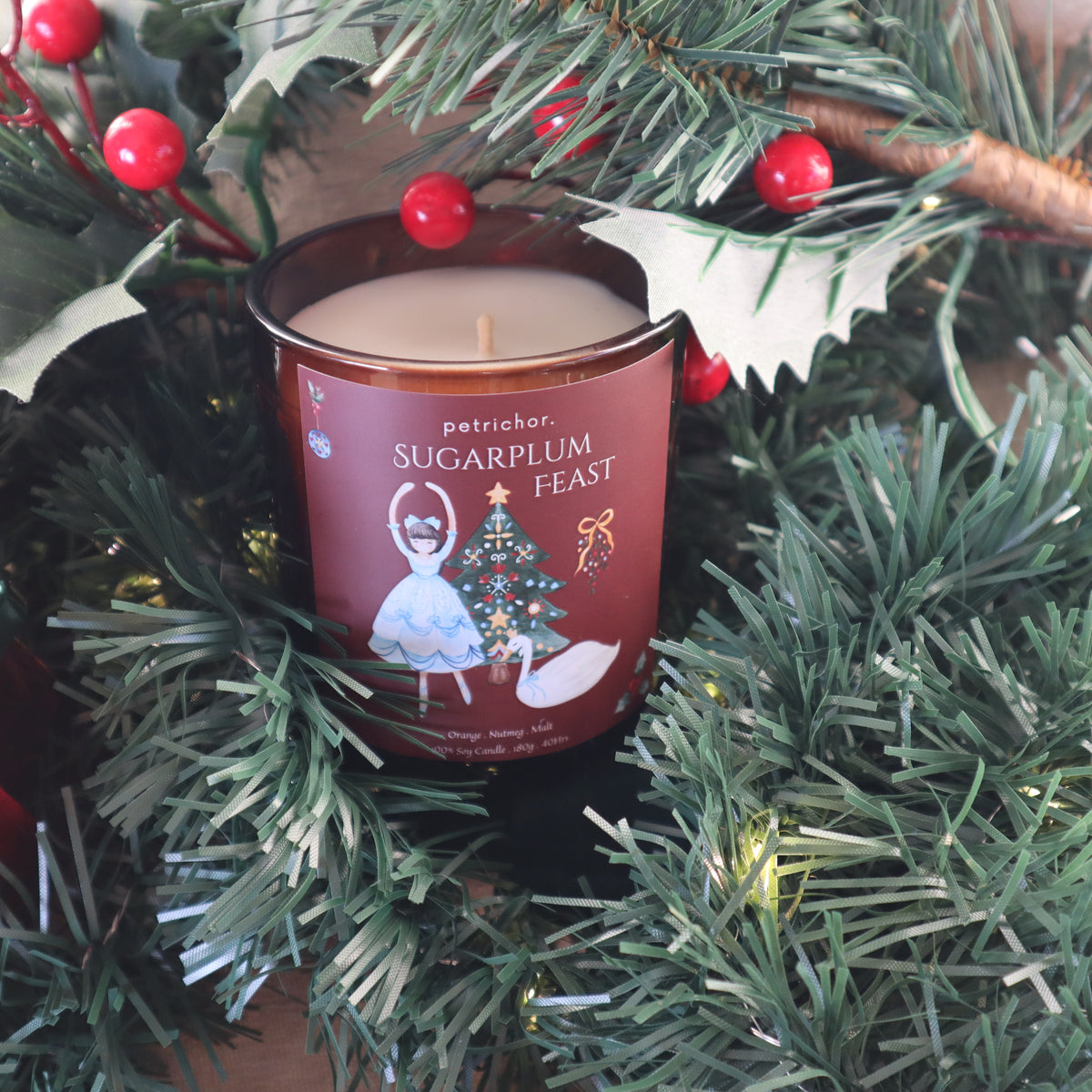Sugarplum Feast Christmas candle among pine branches with red berries