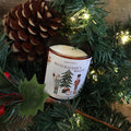 Nutcracker's Waltz Christmas candle among pine branches with a pine cone