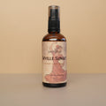 Bottle of Seville Sunset room spray with a decorative label on a beige background
