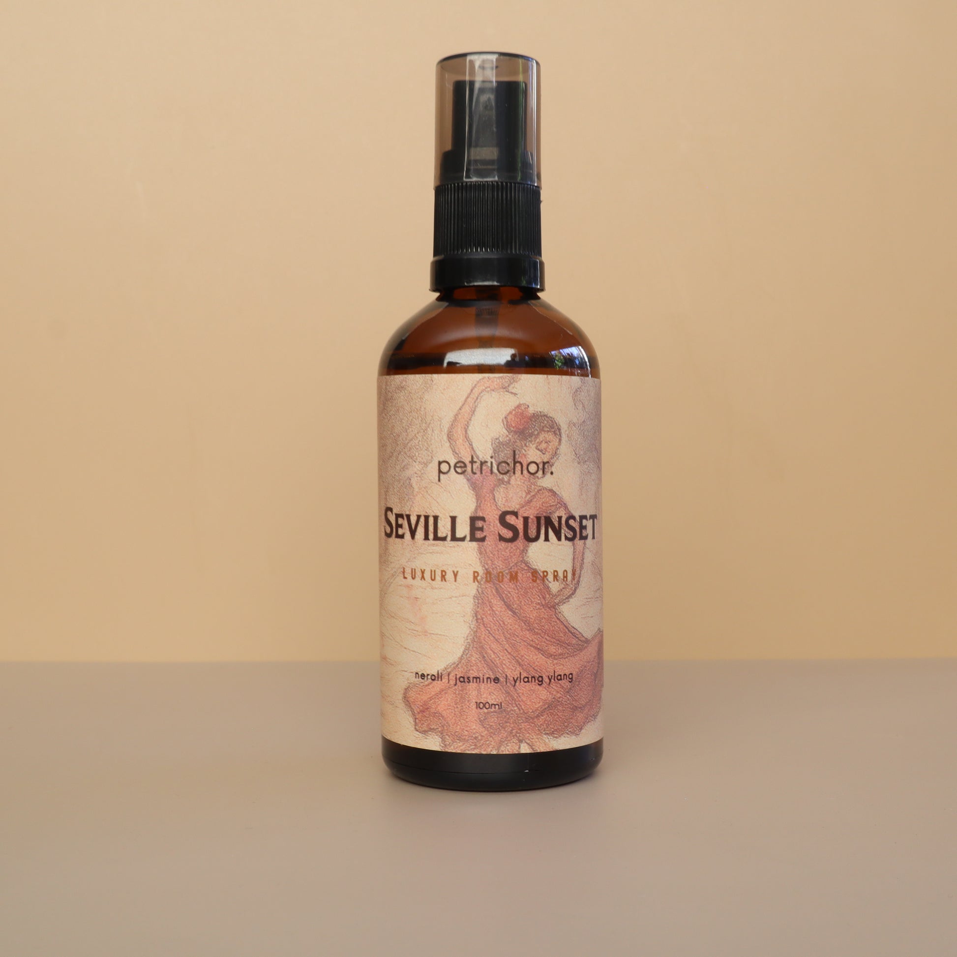 Bottle of Seville Sunset room spray with a decorative label on a beige background