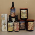 Collection of petrichar products including room sprays bottles and candles with scenic labels on a beige background.