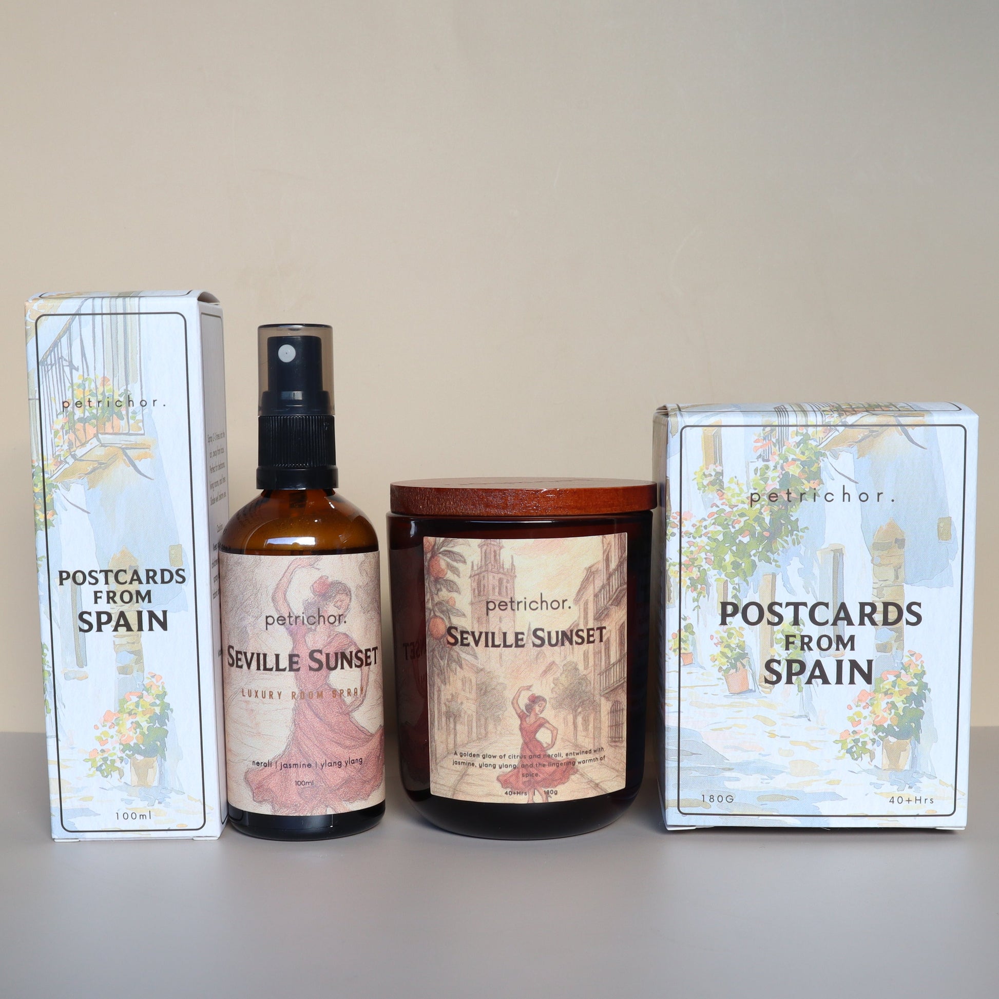 Two boxes labeled 'Postcards from Spain', a bottle, and a candle on a surface.