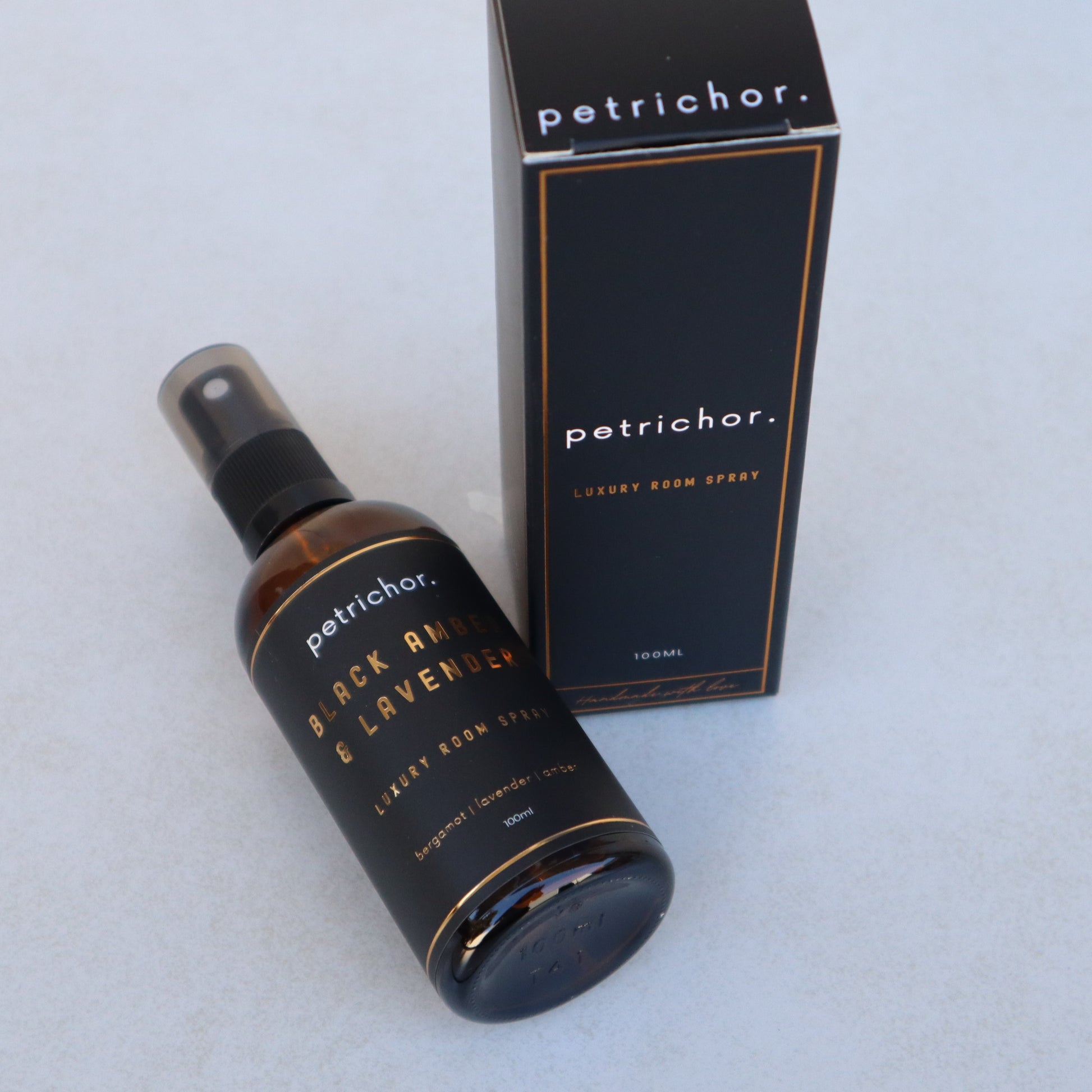 Petrichor Black and Lavender room spray bottle and packaging on a light gray background