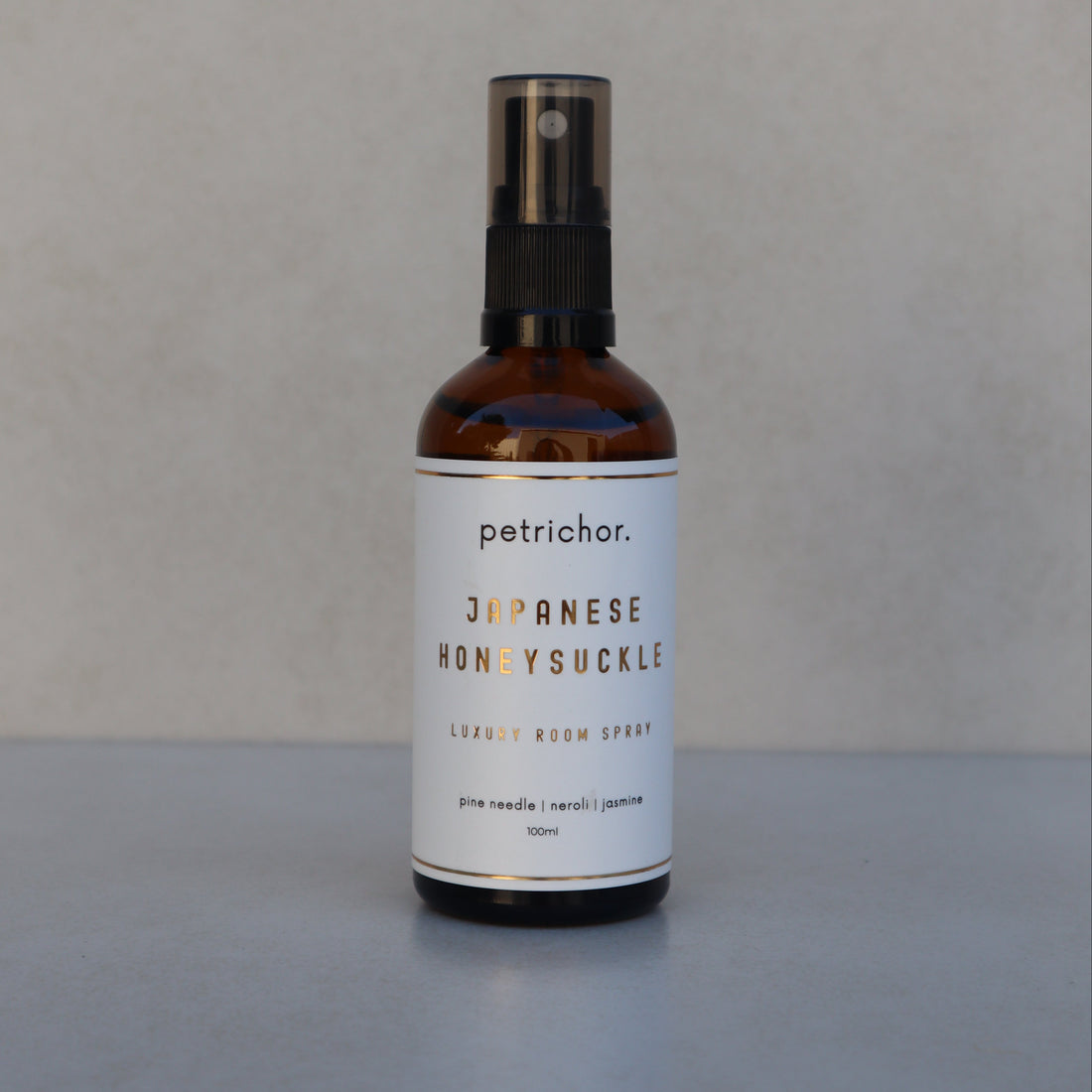 Petrichor Japanese Honeysuckle room spray bottle on a light gray background