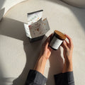 Person holding a jar with a box on a curved surface