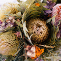 Close-up of a bouquet with protea flowers and greenery on a white background